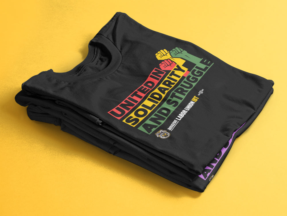 Black t-shirt with colorful text and graphics on a yellow background